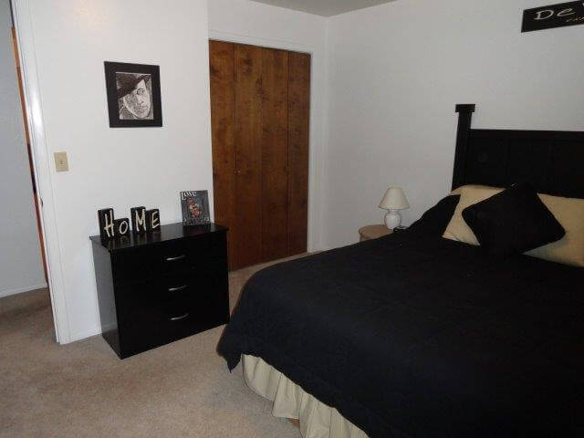 Bedroom, showing queen-sized bed, night table and closet at Crestview 457 East, unfurnished family housing.