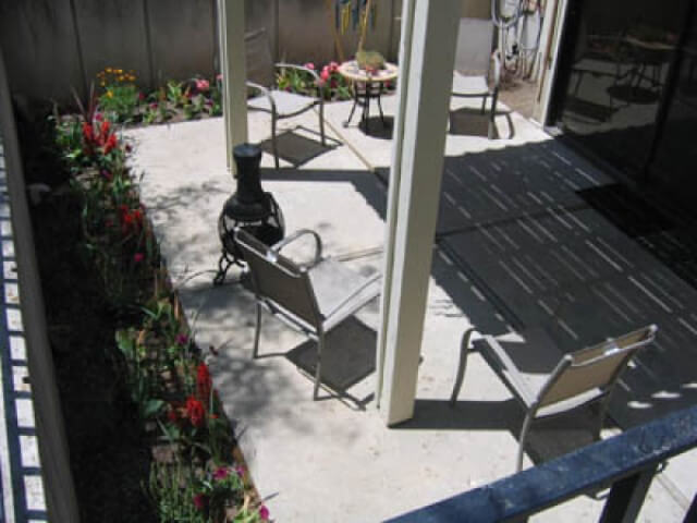 Walk-out patio, partially covered, with flower beds around perimeter at Crestview 457 East, family housing.