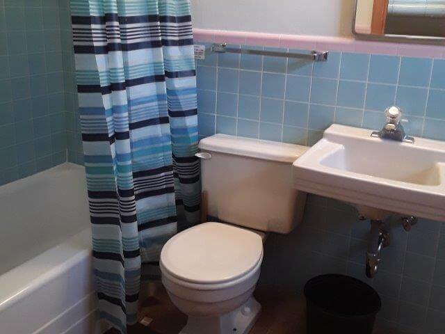 Bathroom 2 showing blue tile, tub/shower, toilet, and sink.